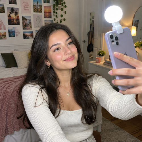 Woman clipping LED selfie light onto phone taking a selfie