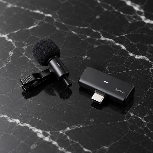 Wireless lavalier microphone on black marble surface, premium studio product shot